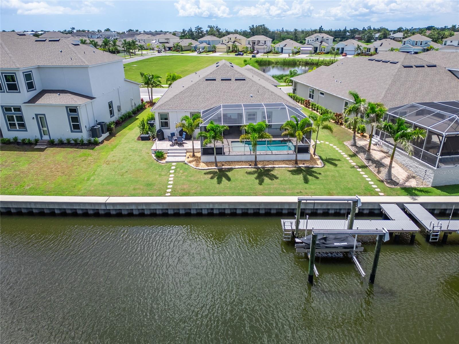 Waterfront home with a screened pool enclosure and dock along the canal.