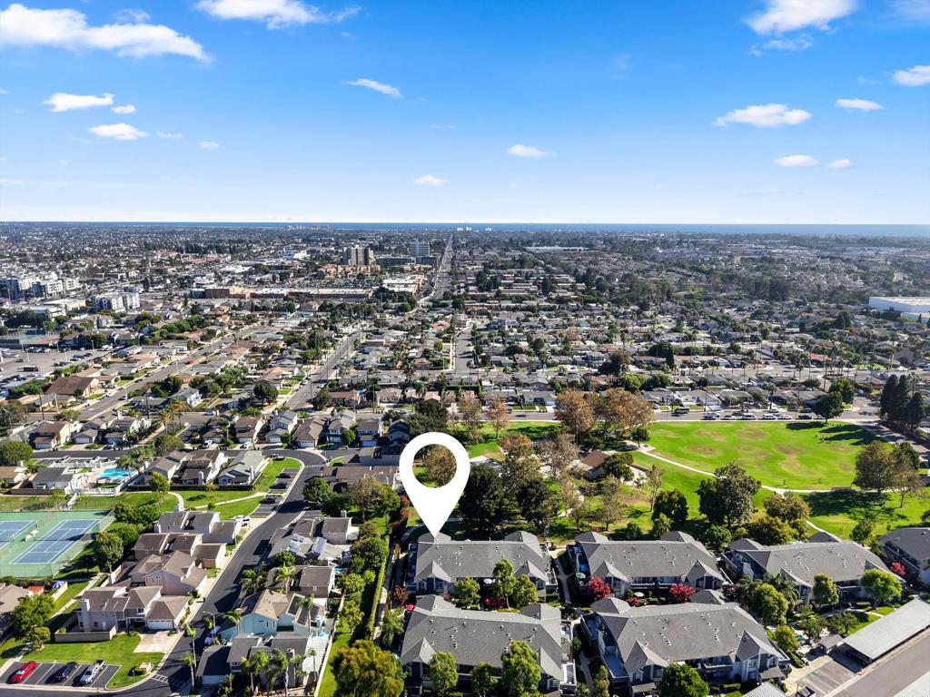 Aerial view of the property and surrounding neighborhood, with a park and tennis courts nearby.