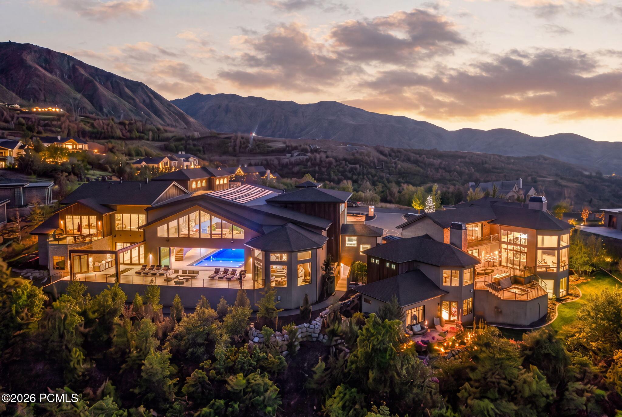 Red Ledges homes with a lit outdoor pool and mountain backdrop at dusk.