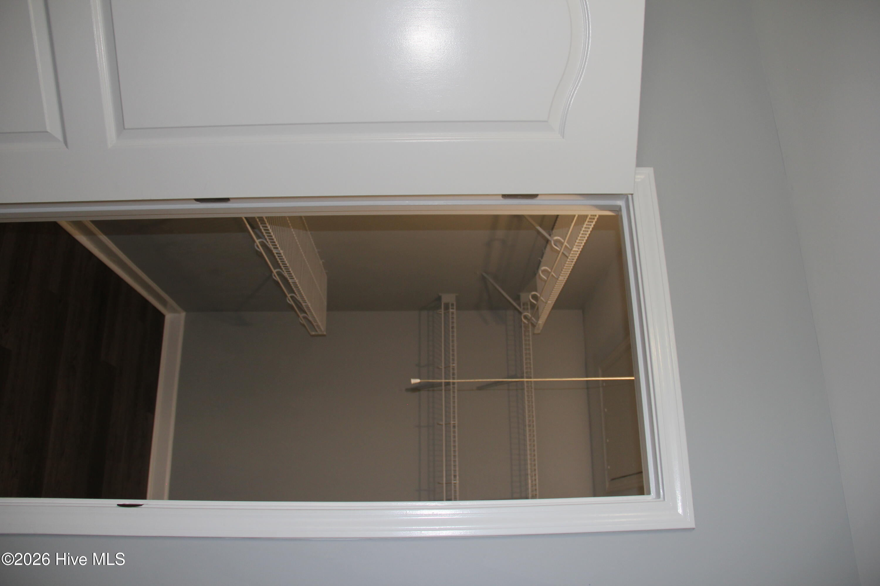 Open closet with empty wire shelving and hanging rods