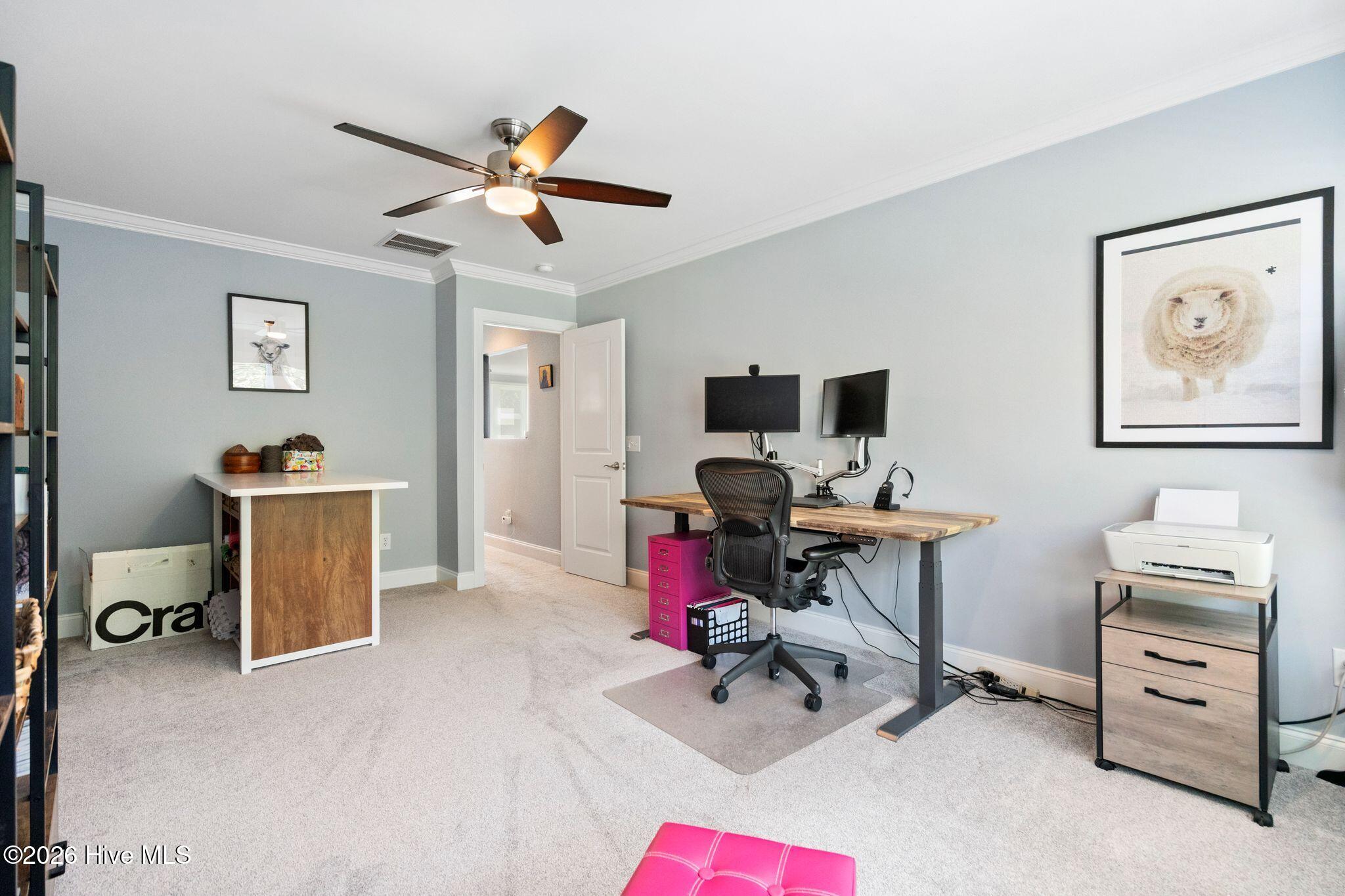 Home office with a dual-monitor standing desk, printer, and framed sheep artwork.