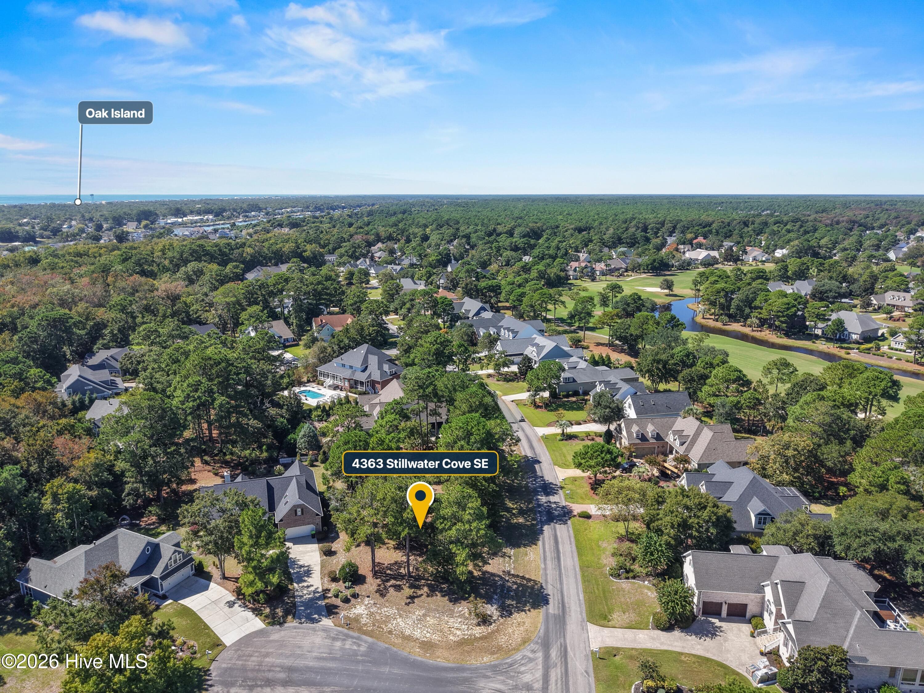Aerial view of 4363 Stillwater Cove SE, with a golf course, pond, and Oak Island labeled in the distance.