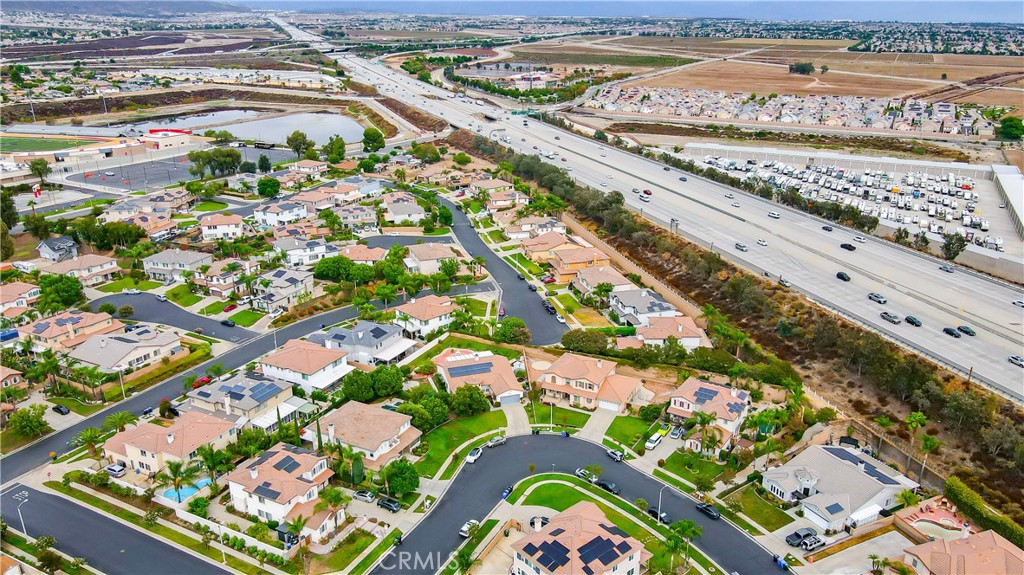 Aerial view of homes and cul-de-sacs beside a major freeway.