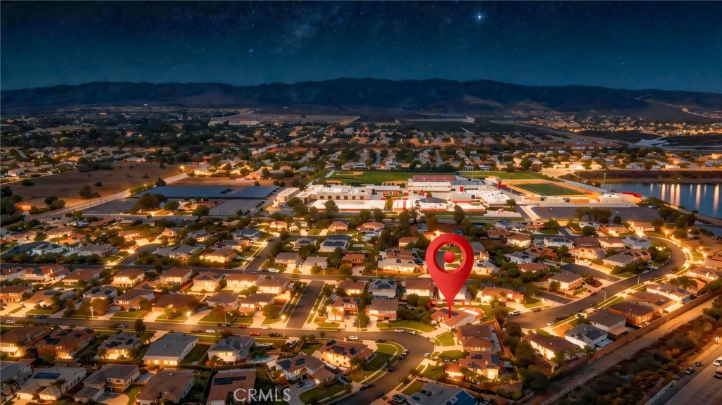 Aerial neighborhood view at night with a red marker indicating the property.