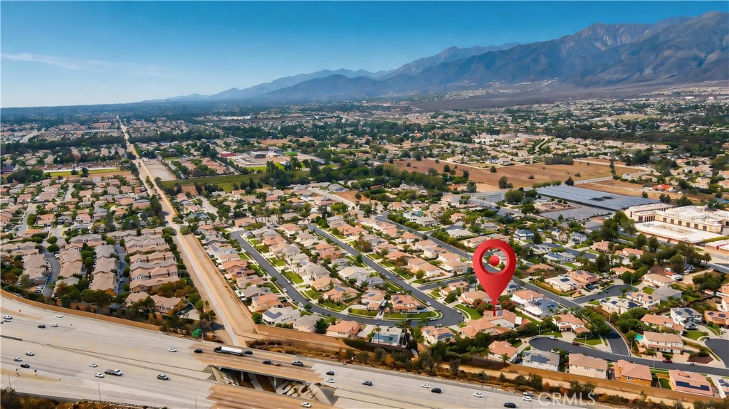 Aerial neighborhood view with a red marker near the property and mountains in the distance.