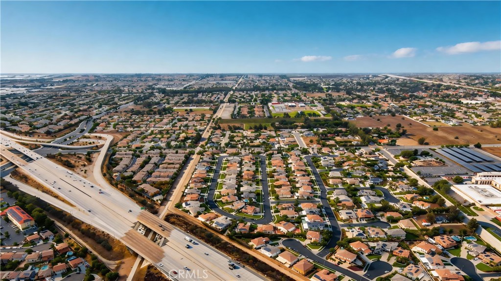 Aerial view of a suburban neighborhood beside a wide freeway interchange.