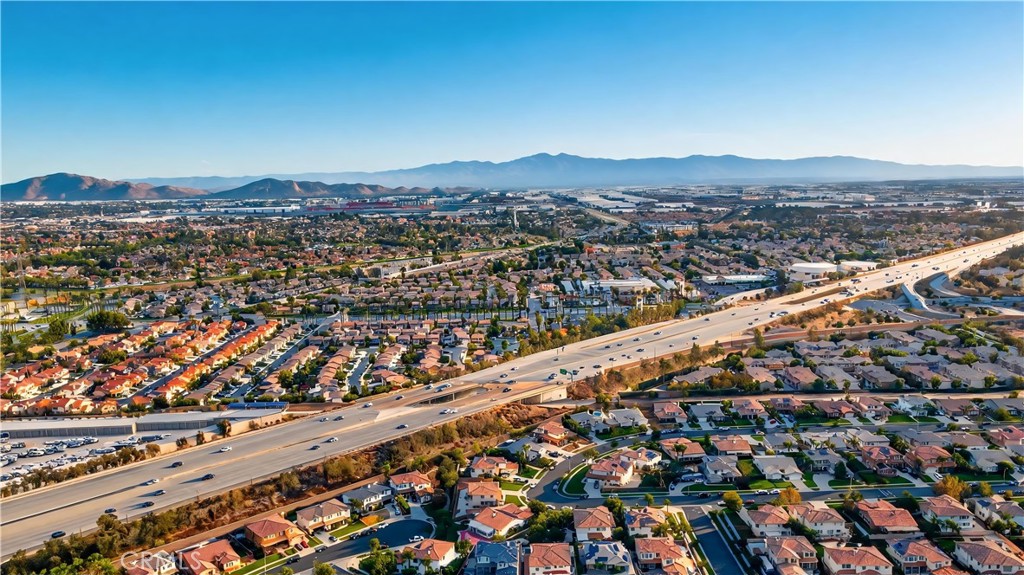 Aerial view of Rancho Cucamonga homes and freeway, with mountains on the horizon.