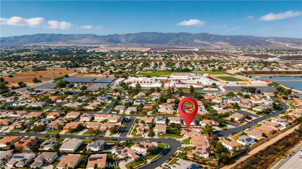Aerial view of 13482 Redwood, marked by a red pin, with mountains beyond the neighborhood.