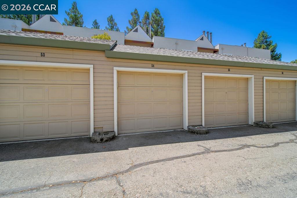 Row of beige numbered garage doors beside a paved driveway.