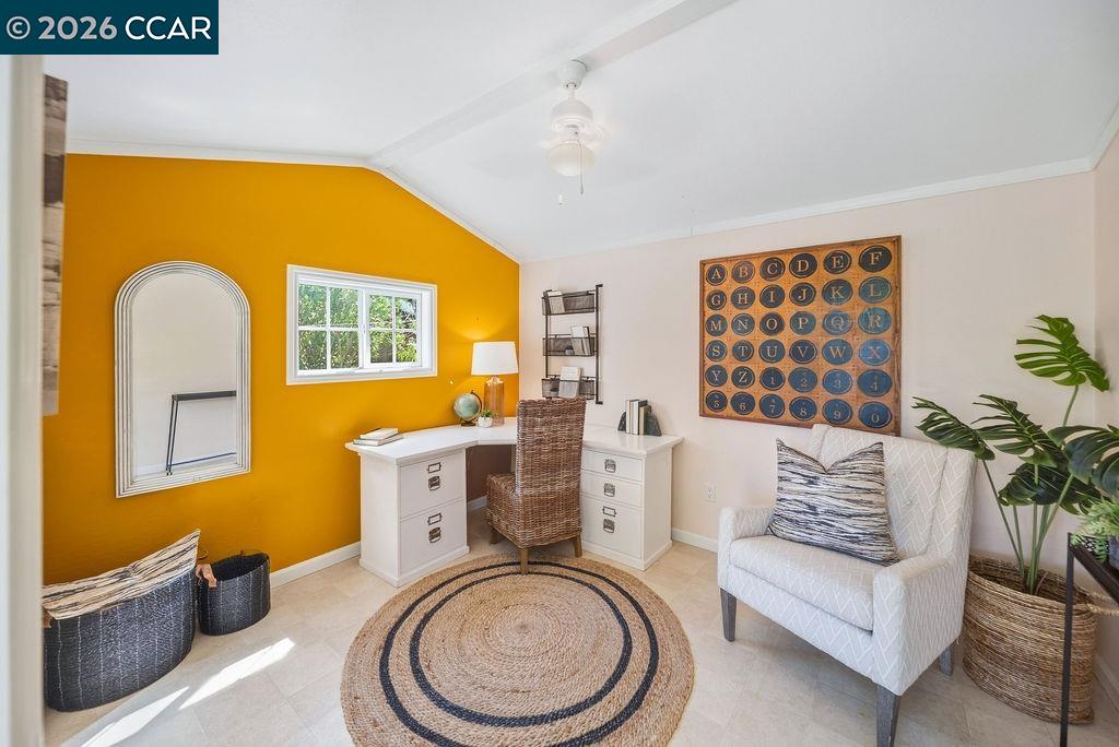 Staged home office with a white desk, mustard-yellow accent wall, and round woven rug.