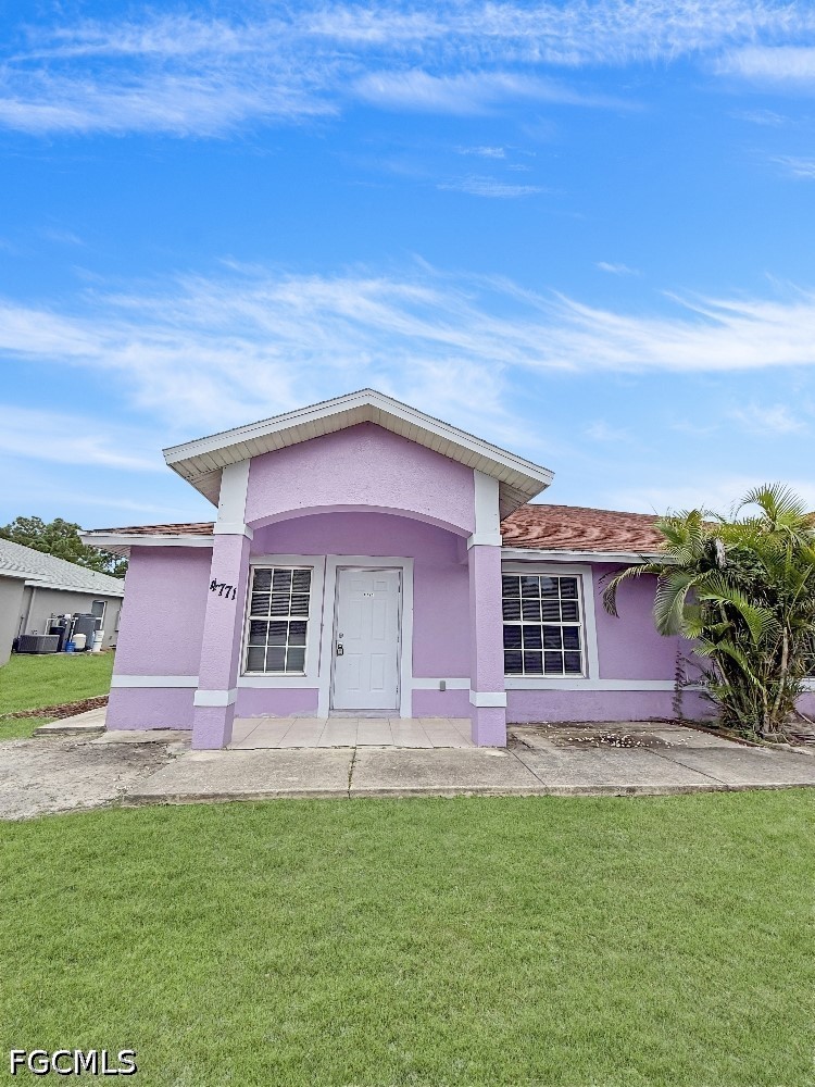 Lavender single-story house with white trim, covered entry, and green lawn.