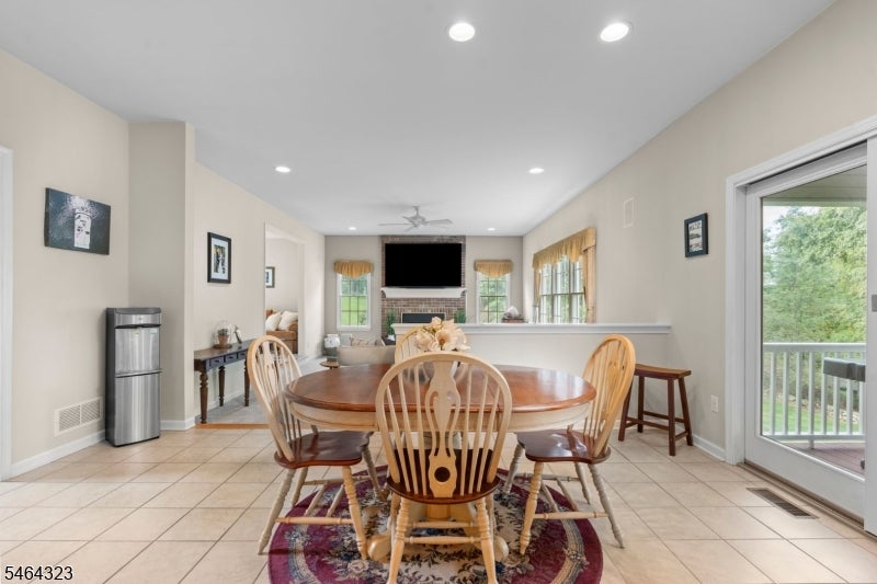 Dining area with a round wooden table, patterned rug, and sliding glass door to a deck.