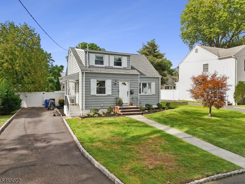 Gray two-story house with white trim, a wide driveway, and a front lawn.