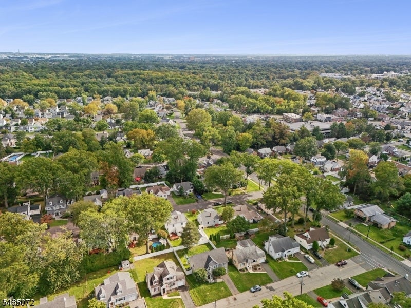 Aerial view of a leafy suburban neighborhood with detached homes and tree-lined streets.
