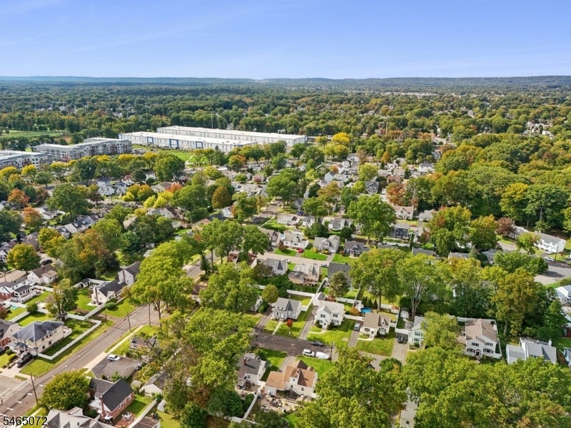 Aerial view of a leafy suburban neighborhood with detached homes and tree-lined streets.