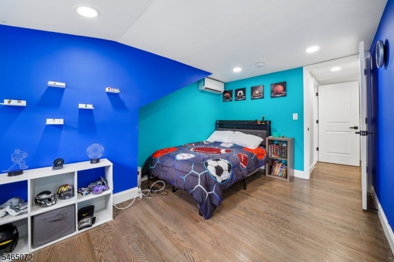 Bedroom with sports-themed bedding, bright blue and turquoise walls, and sports memorabilia on display.