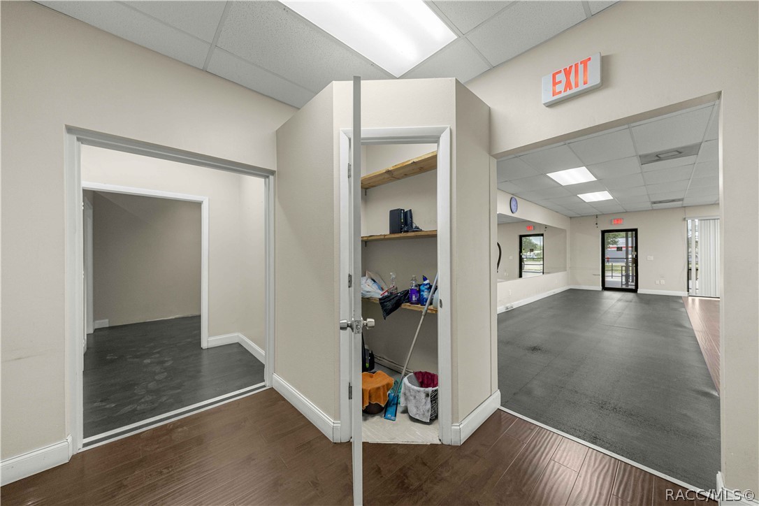 Vacant commercial interior with an open storage closet and a large room beyond.