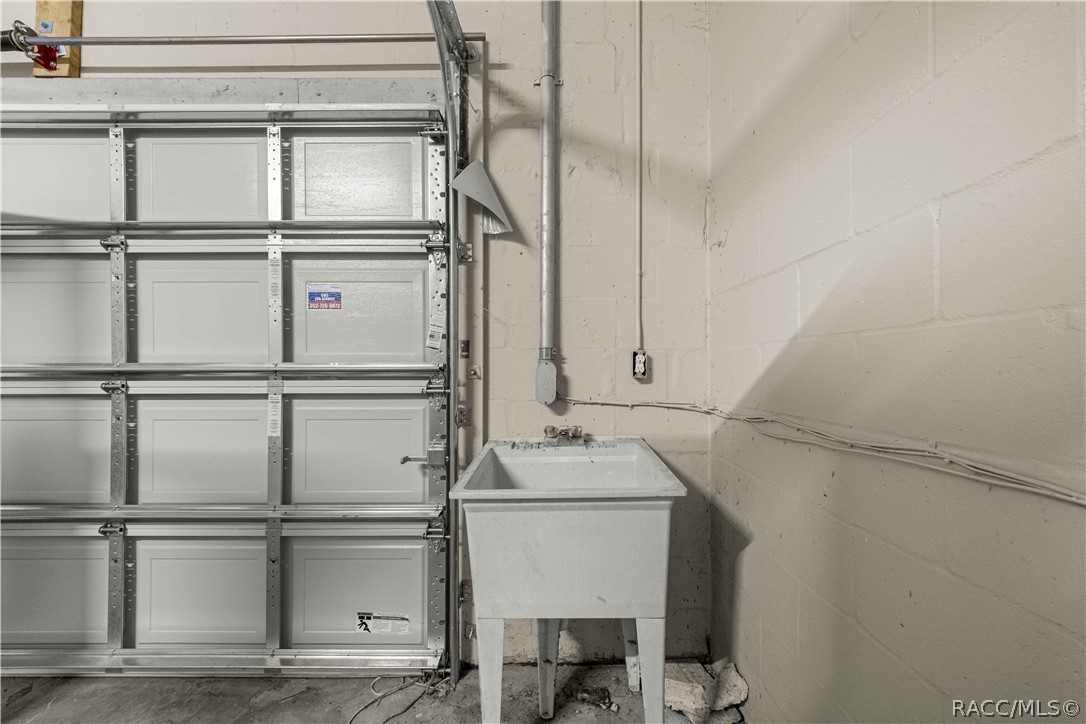 Garage with a sectional door and freestanding utility sink.