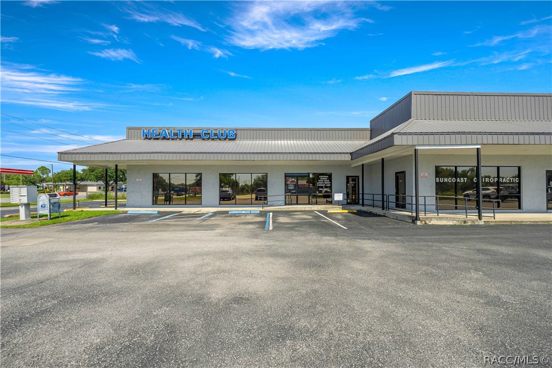 Commercial building with HEALTH CLUB and Suncoast Chiropractic signs facing a parking lot.
