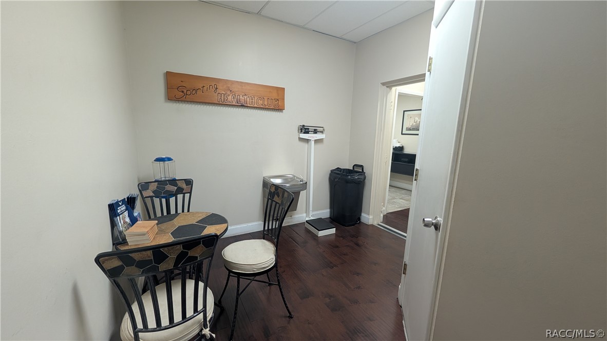 Health club room with a round table, chairs, drinking fountain, and scale.