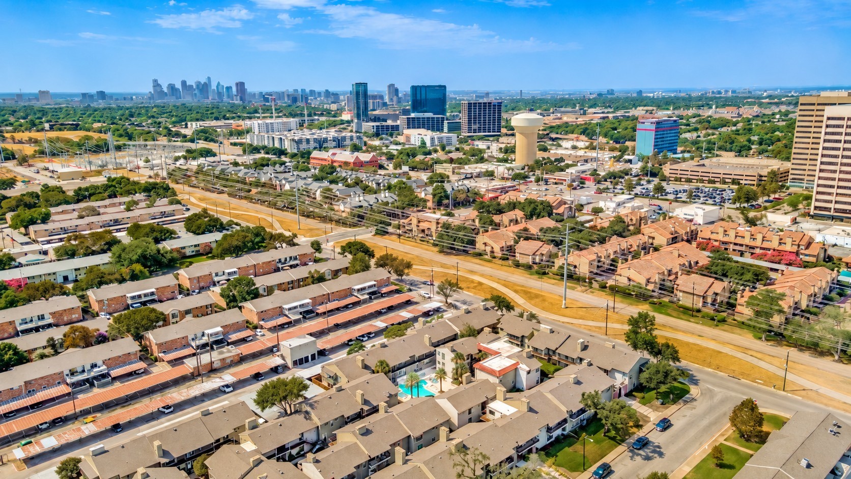 Aerial view of Dallas homes and apartments with the downtown skyline in the distance.