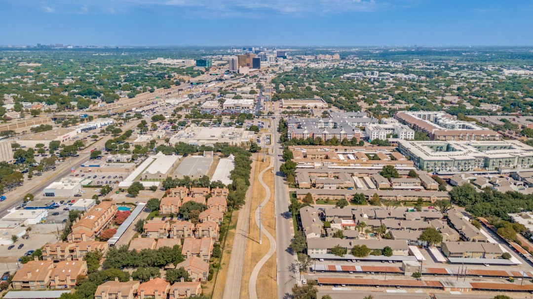 Aerial view of Dallas apartments and neighborhoods with the downtown skyline in the distance.
