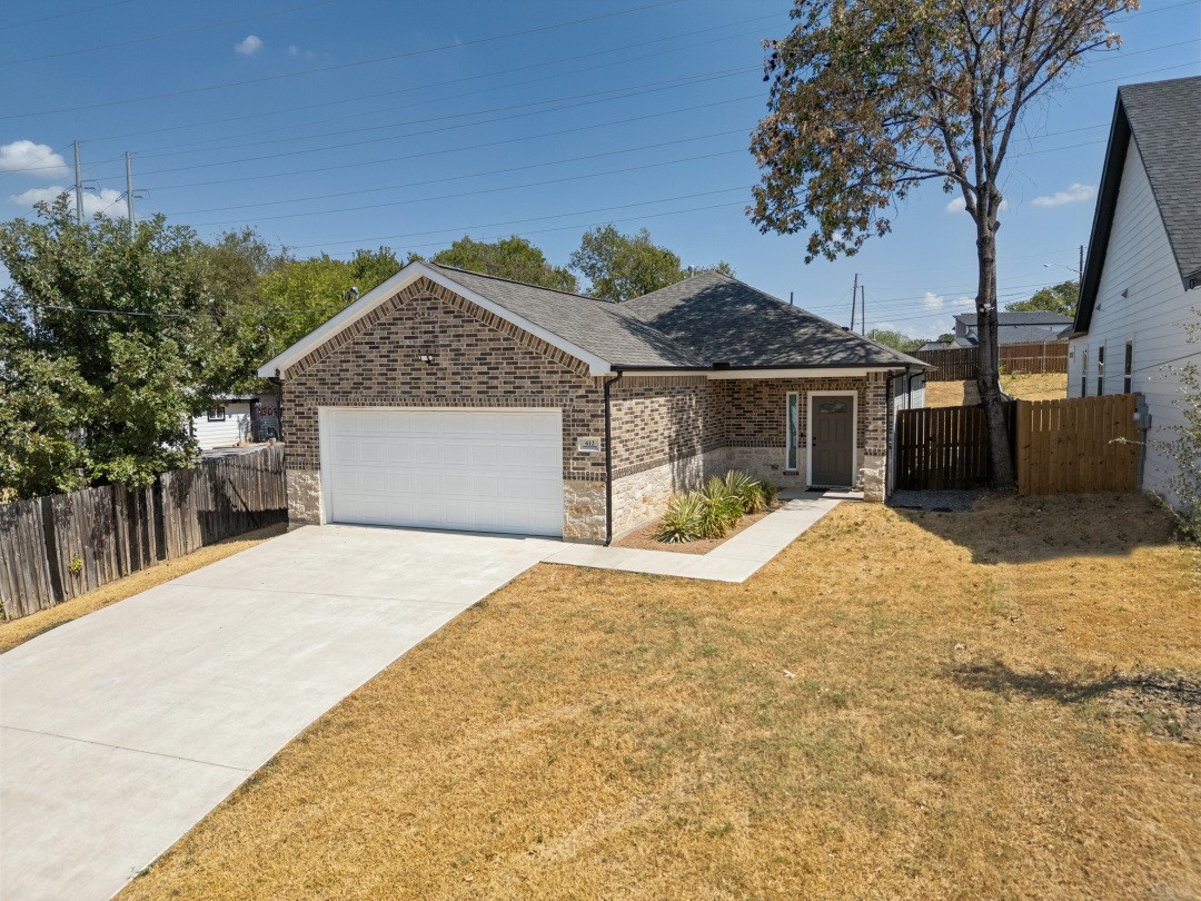 Brick house with stone veneer, a wide driveway, and a covered front entry.