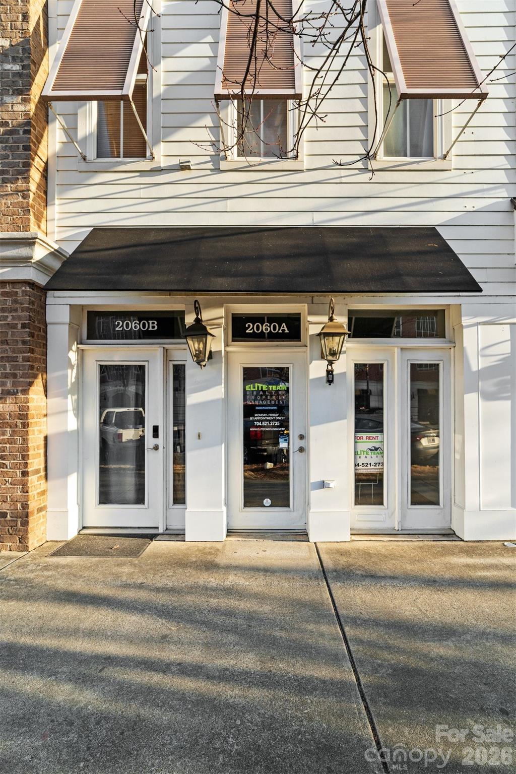 Commercial storefront with adjoining 2060A and 2060B entrances beneath a black awning.