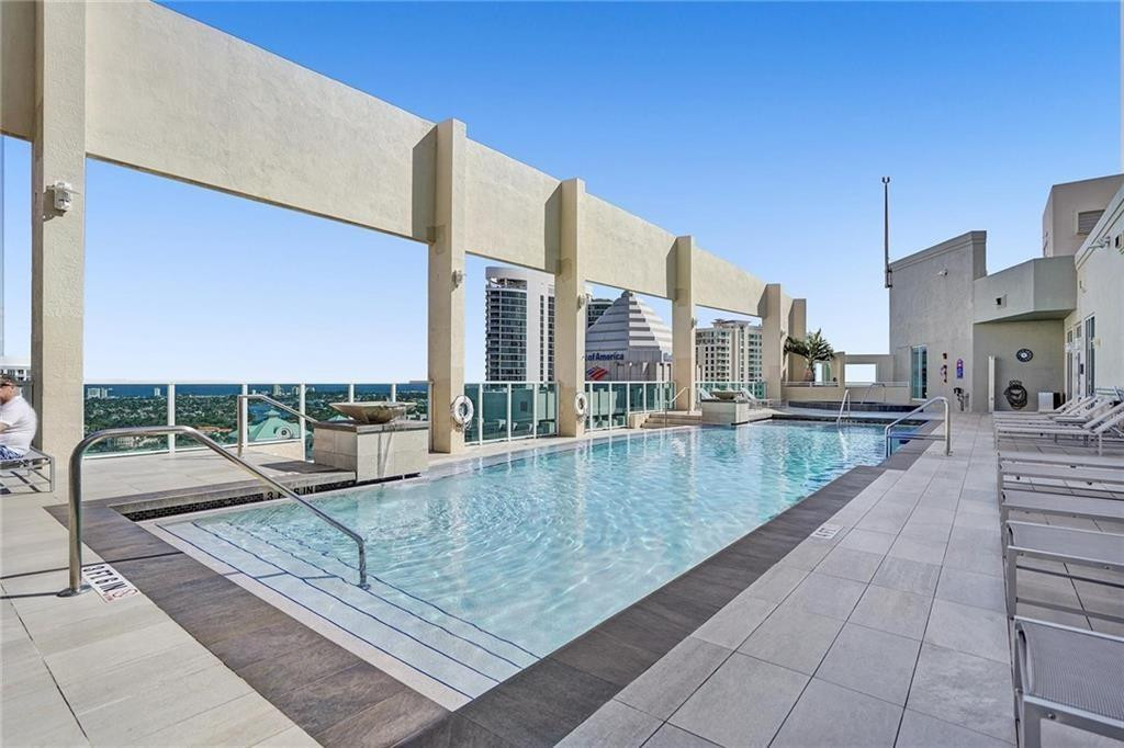 Rooftop pool with lounge chairs and a view of Fort Lauderdale high-rises.