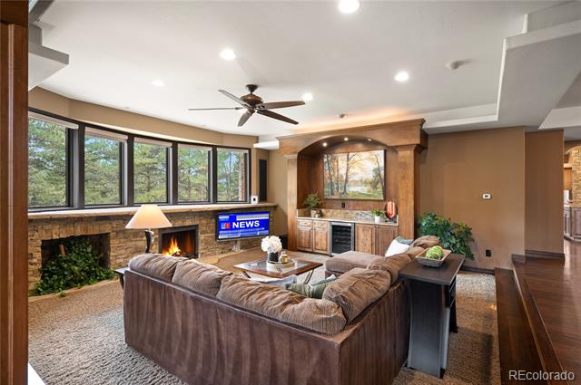 Living room with a brown sectional, brick fireplace, and built-in wood entertainment center.