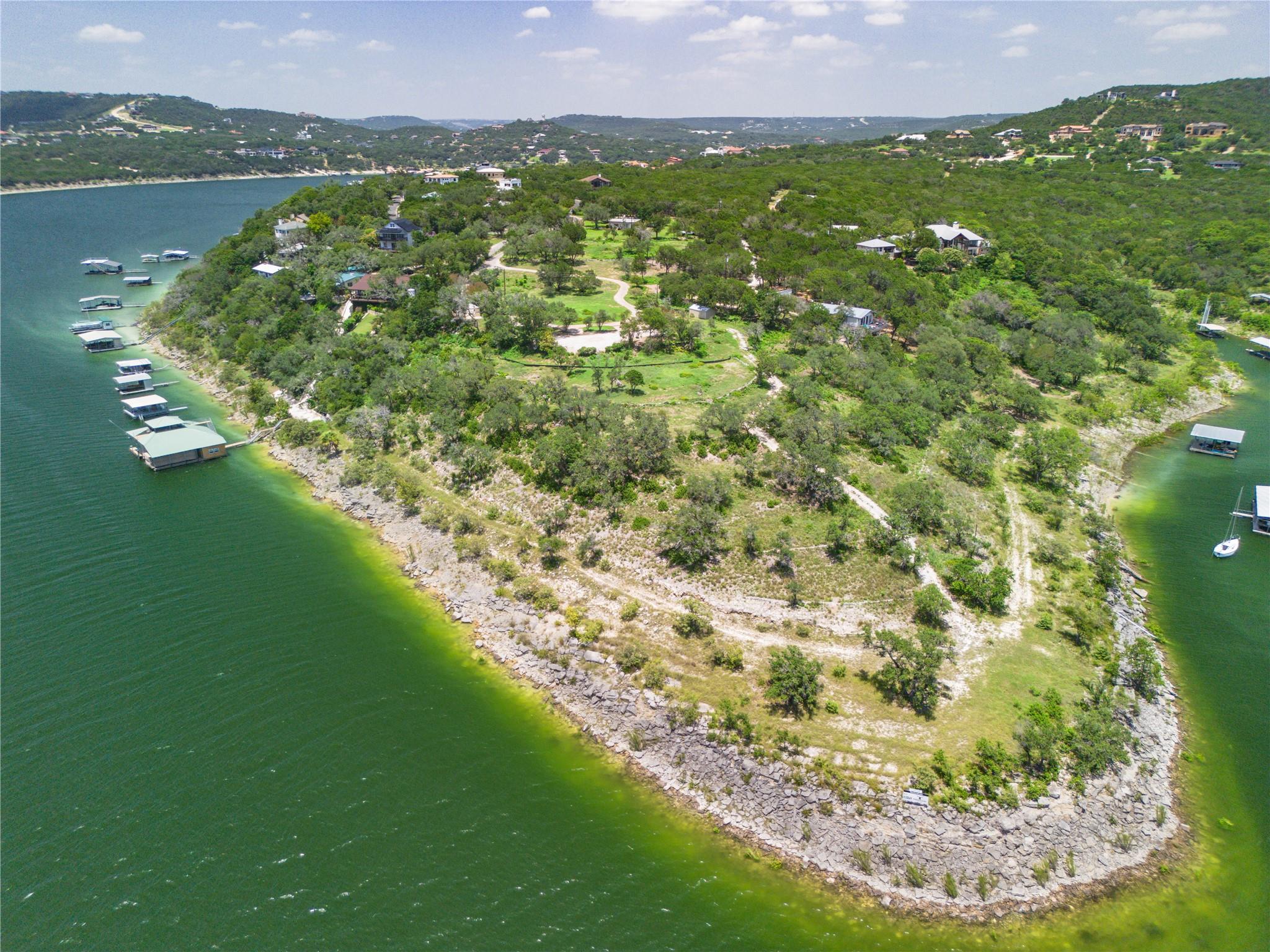 Wooded waterfront peninsula with scattered homes, winding paths, and boat docks.