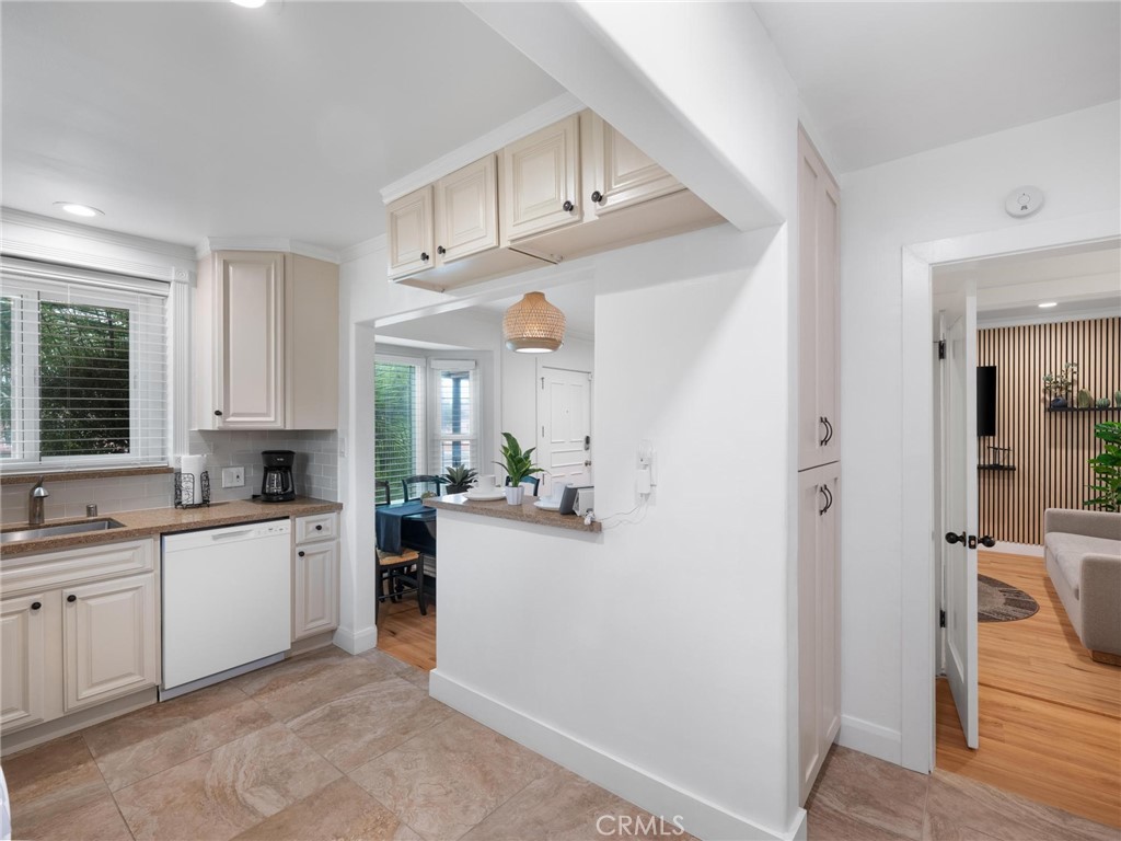 Kitchen with white cabinetry and a pass-through counter overlooking the dining nook.