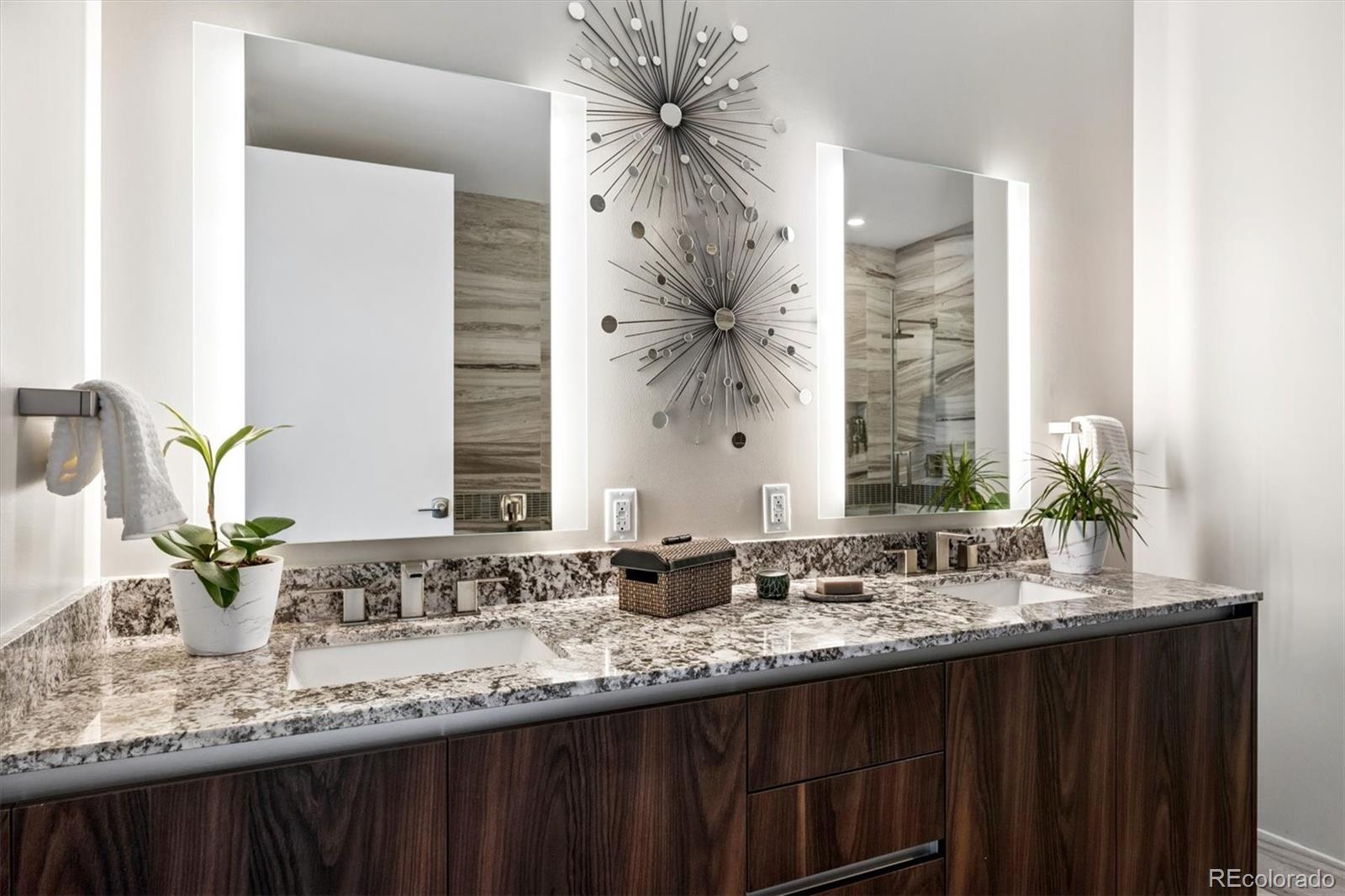 Bathroom vanity with dual sinks, granite countertop, and dark wood cabinets.