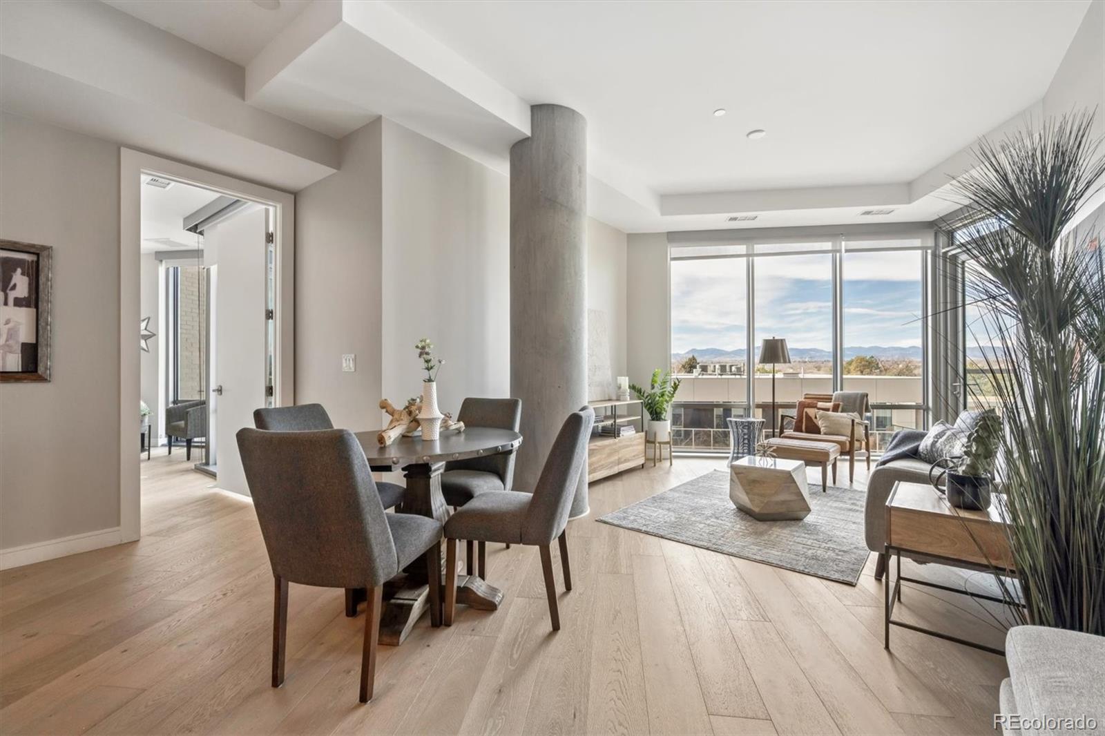 Open-plan living and dining room with floor-to-ceiling windows and mountain views.