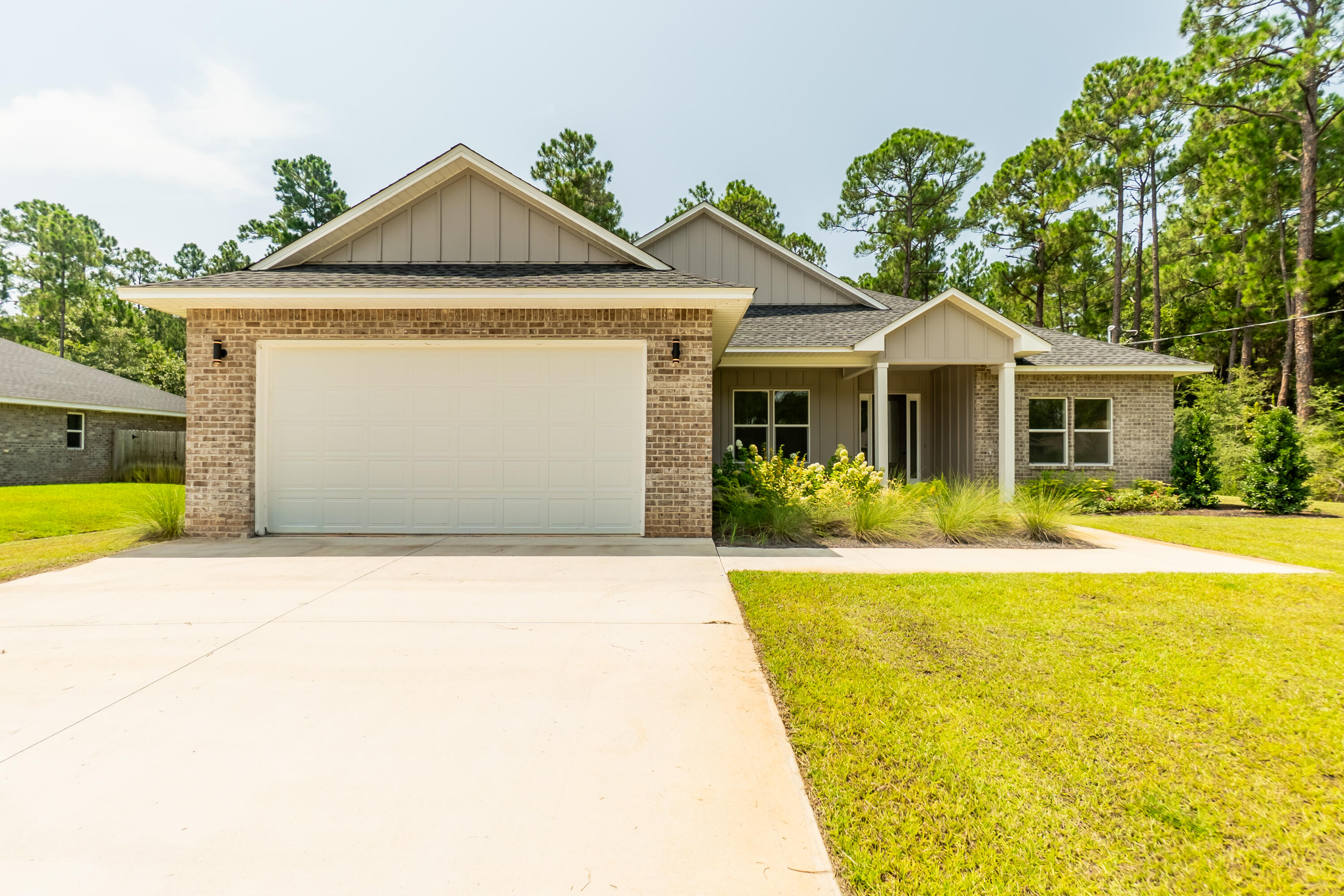 Single-story brick house with an attached garage, covered entry, and landscaped front lawn.
