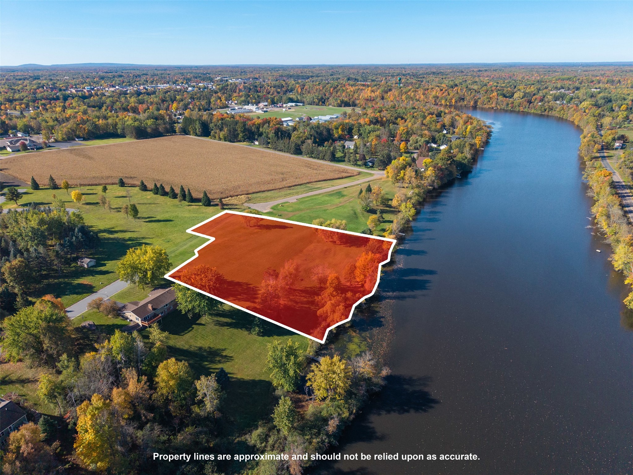 Riverside parcel outlined in red beside a broad river, surrounded by autumn trees.