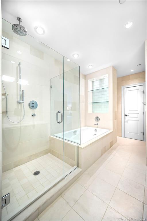 Bathroom with a glass-enclosed shower beside a built-in soaking tub.