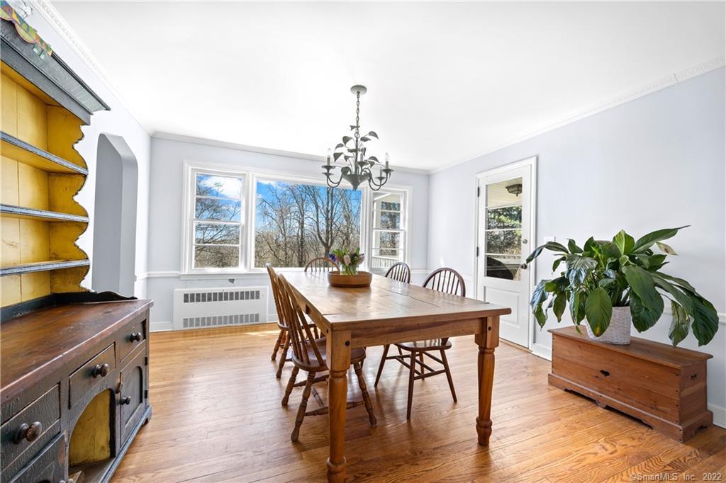 Dining room with a wooden table, hardwood floors, built-in shelving, and large windows.