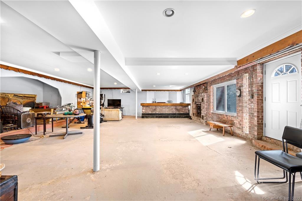 Unfinished basement with a concrete floor, exposed brick walls, and a small counter.