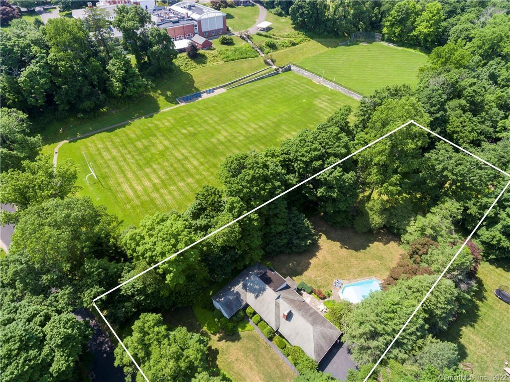 Aerial view of a wooded property with a house, swimming pool, and outlined boundaries.