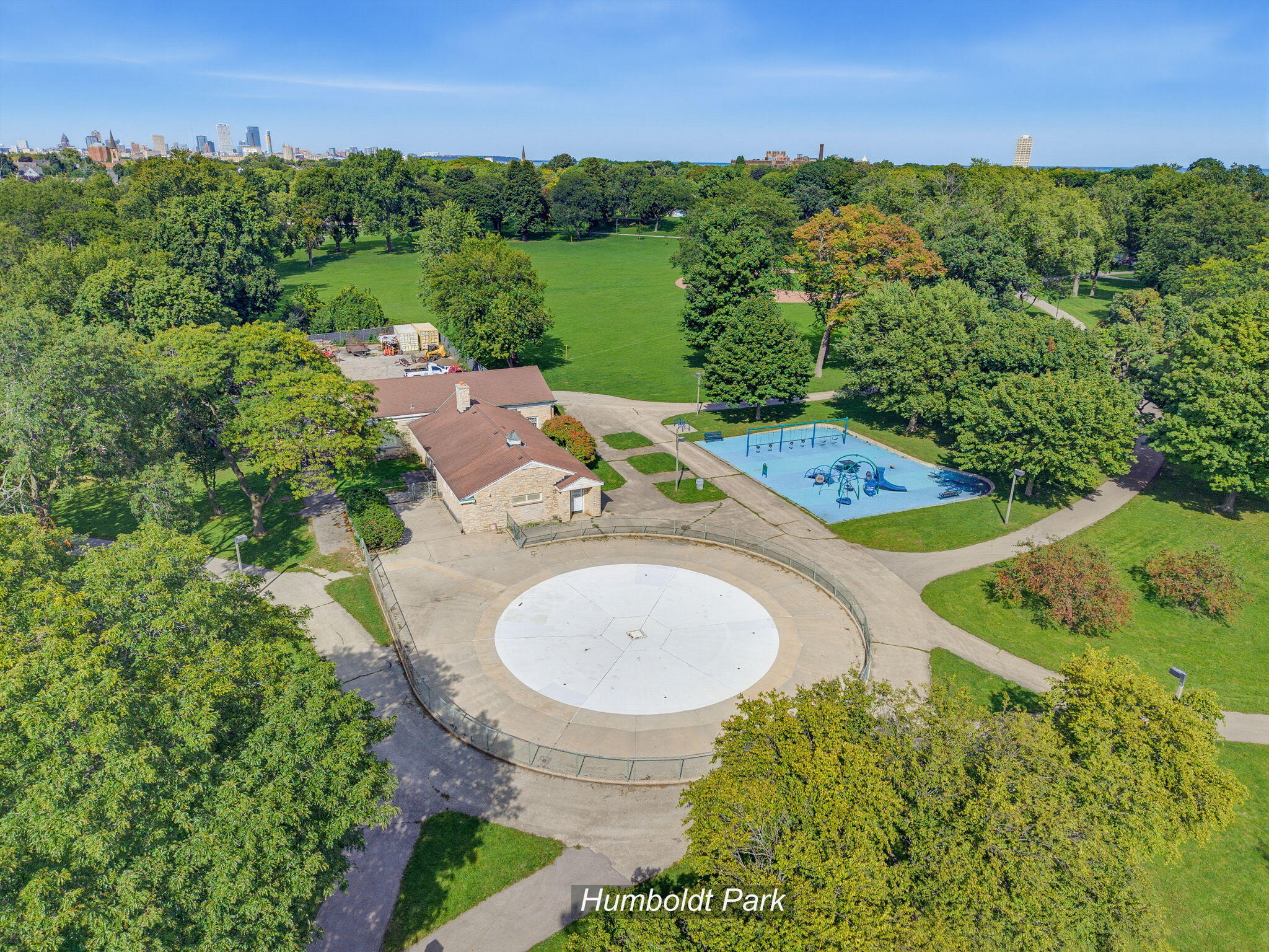 Aerial view of Humboldt Park’s circular plaza, playground, lawns, and Milwaukee skyline.