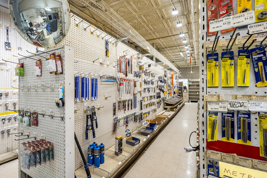 Hardware store interior with tool displays along a long aisle and a patterned tin ceiling.