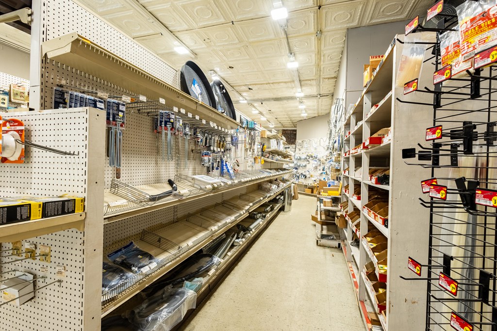 Hardware store aisle with stocked shelves and pegboard displays.