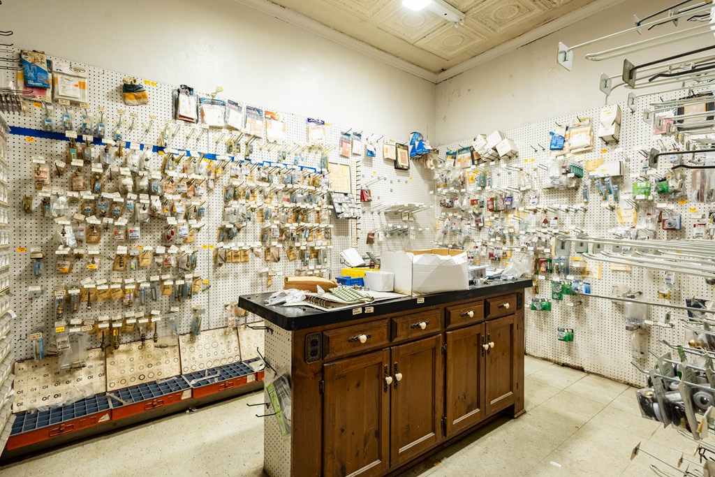 Retail shop interior with pegboard displays of merchandise and a central wooden counter.
