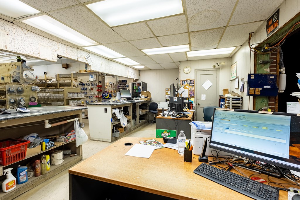 Commercial shop interior with stocked service counters and several computer workstations.