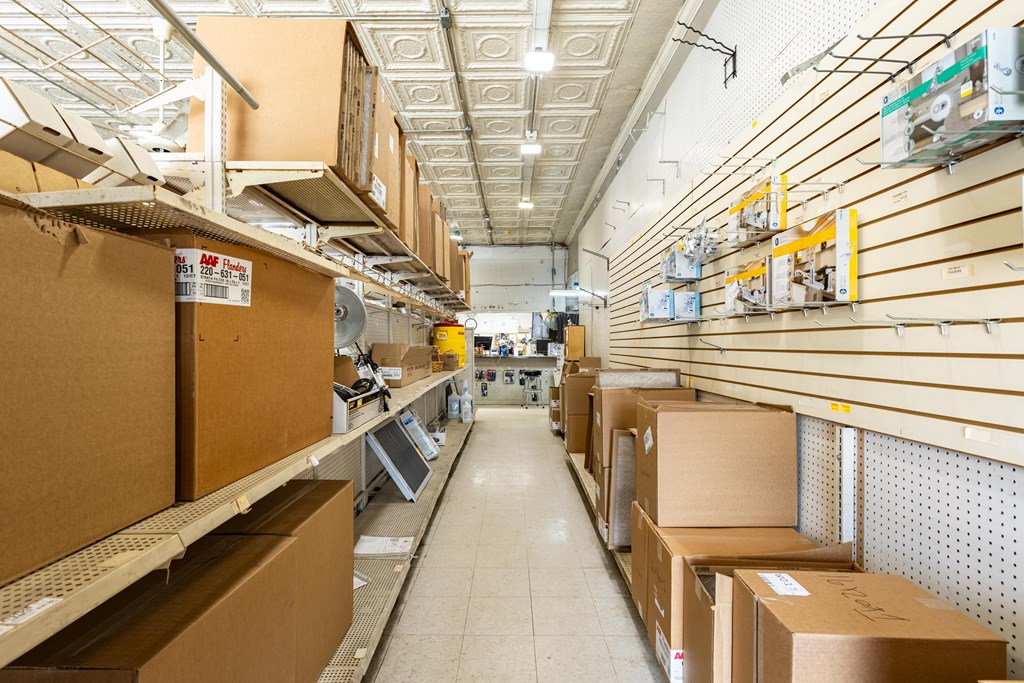 Retail store interior with slatwall shelves, boxed inventory, and a tiled aisle.