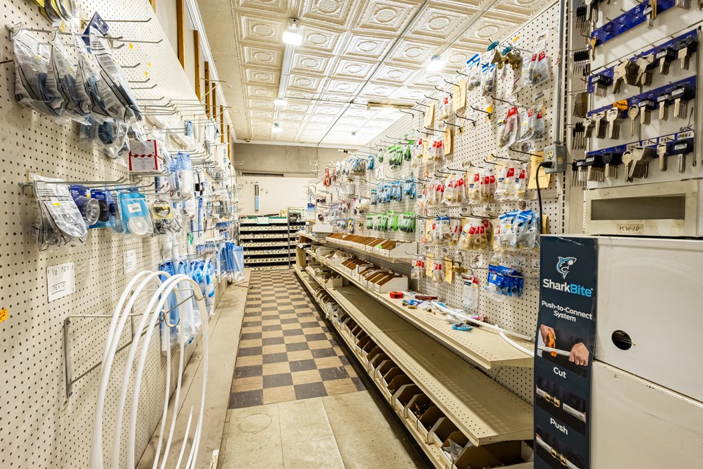 Plumbing supply store interior with pegboard displays, long counters, and a checkerboard aisle.