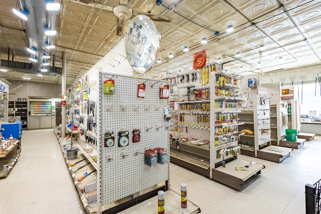 Hardware store interior with stocked pegboard displays and a patterned tin ceiling.