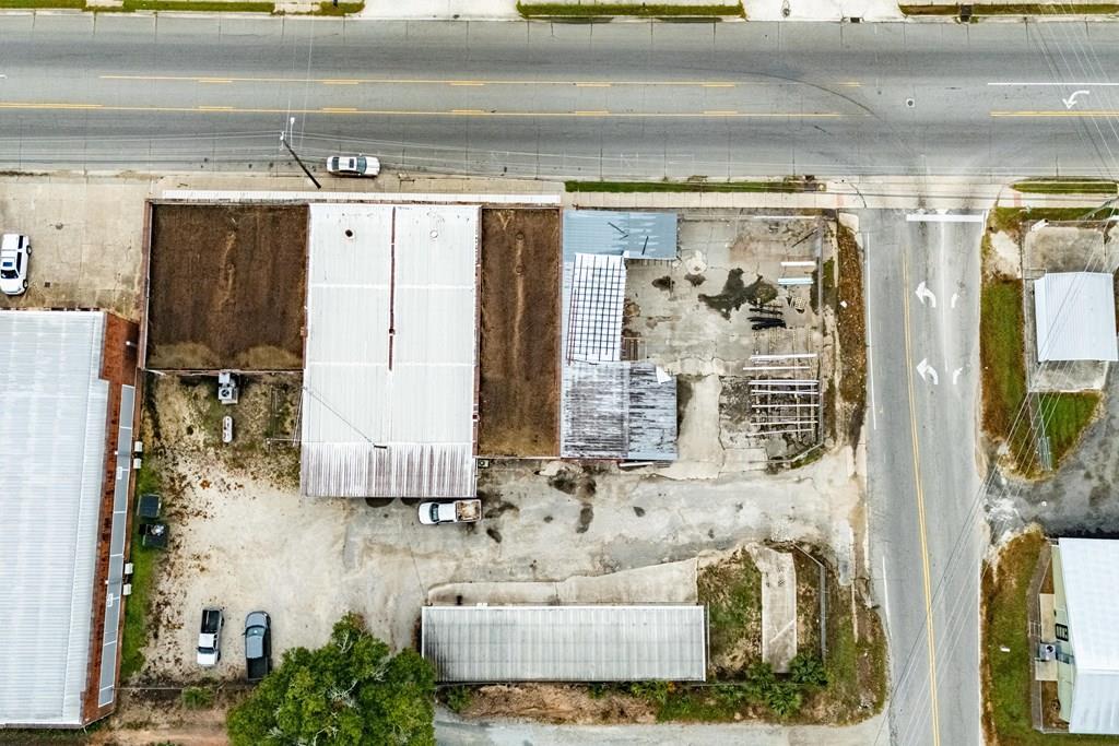 Commercial property with multiple buildings and a paved lot beside two roads.