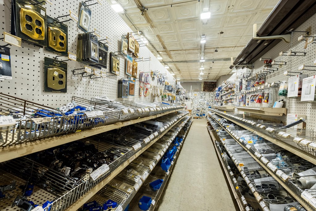 Hardware store aisle lined with electrical supplies, wall displays, and wire shelving.